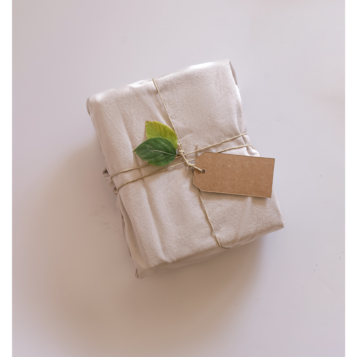 Nachhaltigkeit ist uns wichtig Ein liebevoll verpacktes Päckchen mit einem grünen Blatt und einer Anhängerkarte.